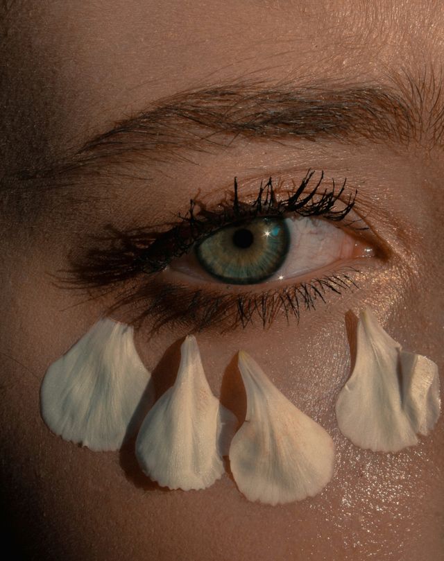 Close-up beauty portrait with delicate white petals beneath the eye